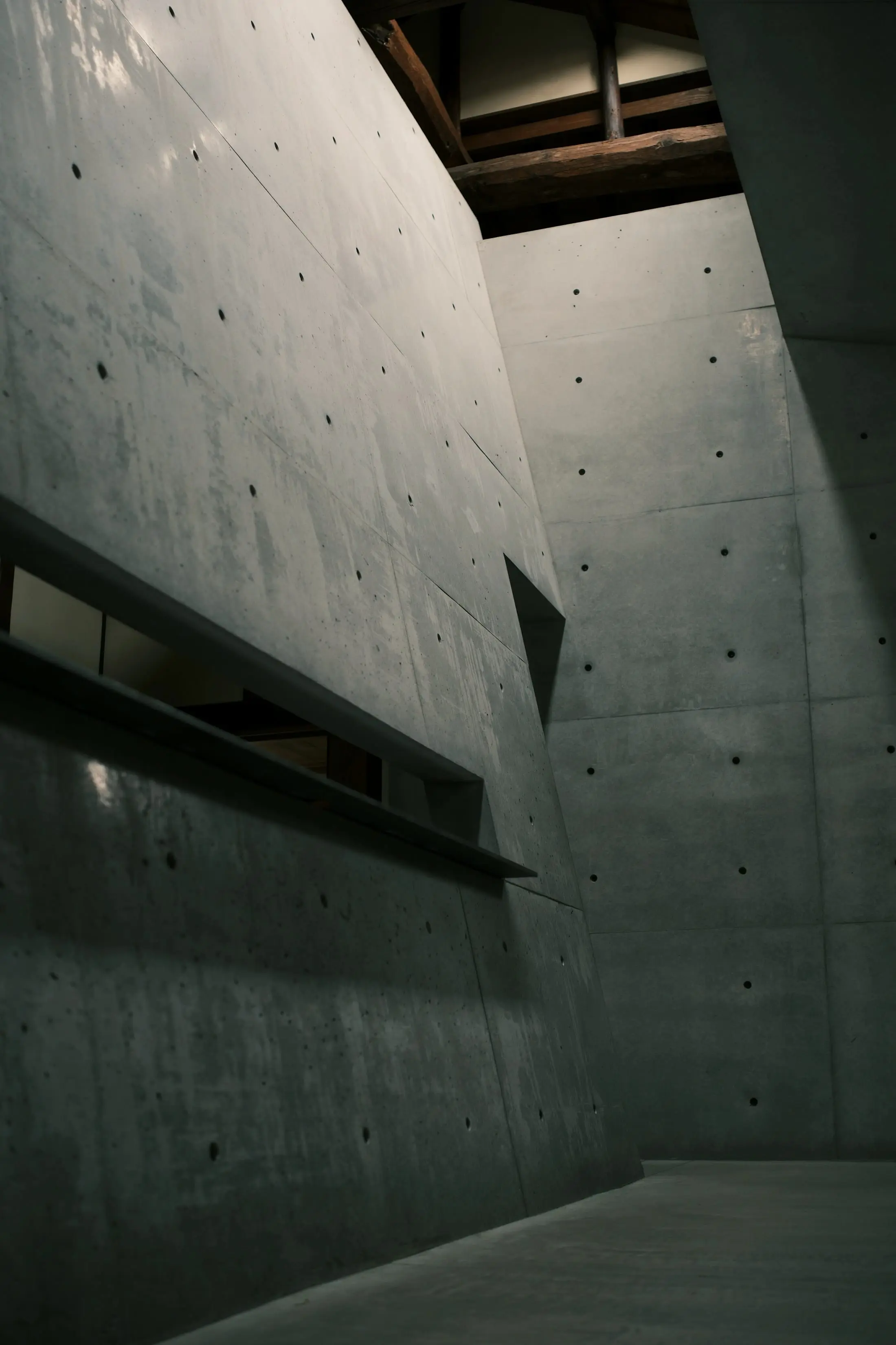 Tall concrete wall with a recessed slot and a diagonal fall of light