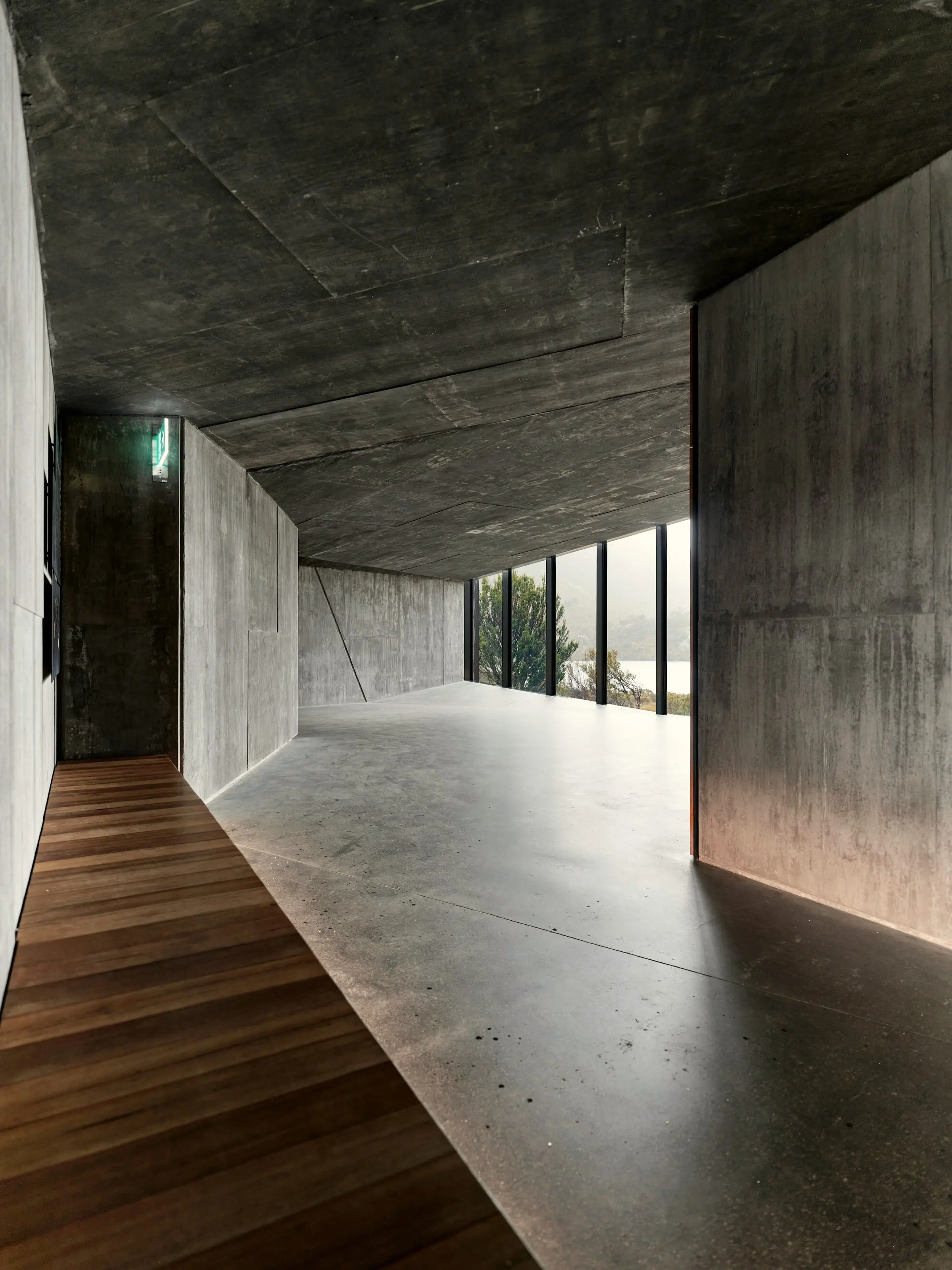 Concrete corridor with an oak floor running to a glazed end wall