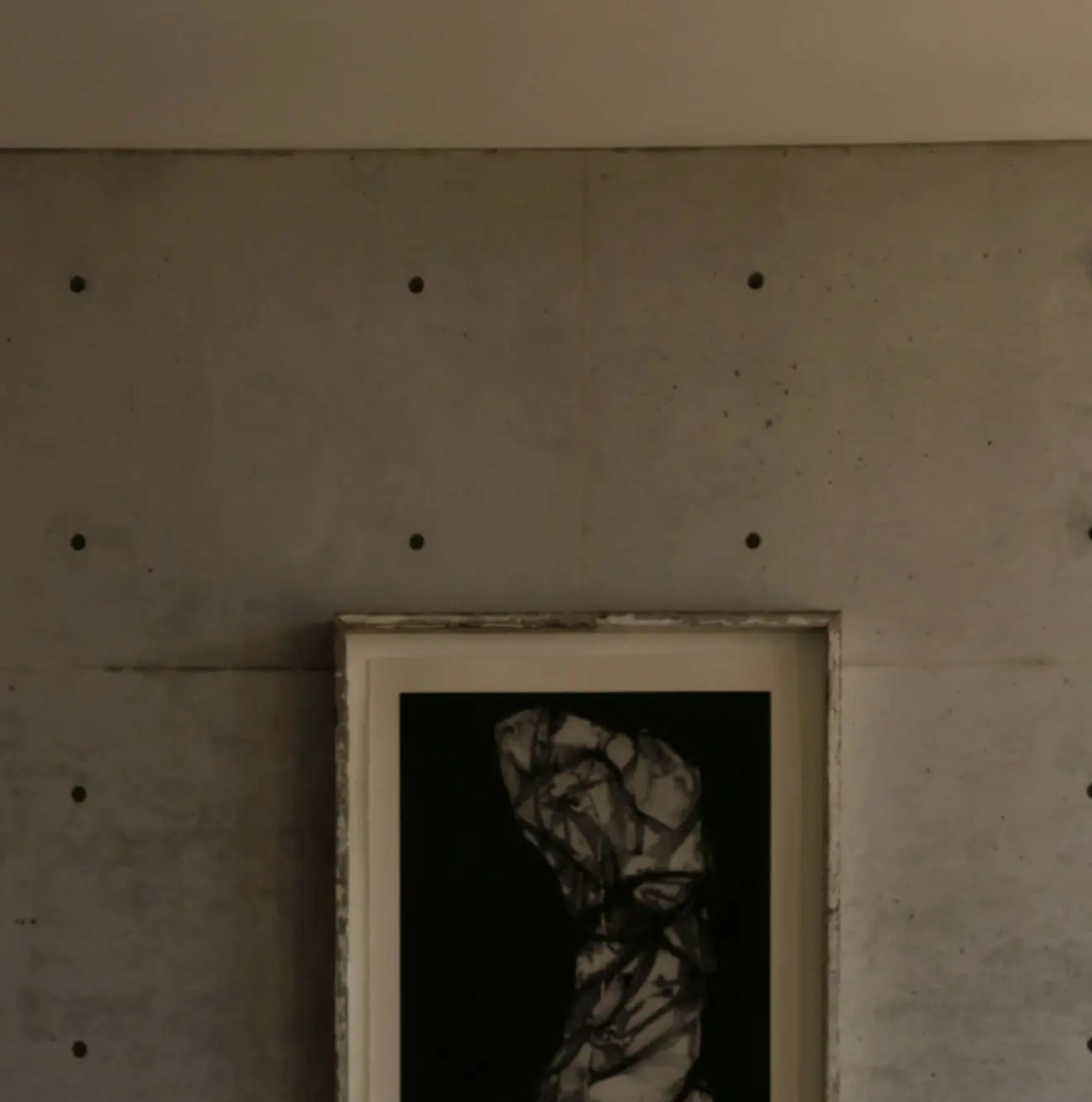 Detail of an artwork hung on board-marked concrete